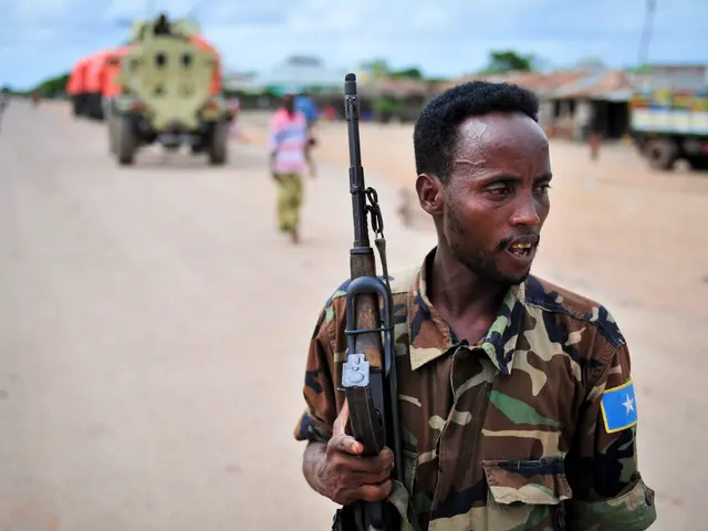 The image shows a Somali soldier standing guard at the site of a suicide attack in Mogadishu,...