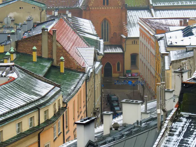 The image shows a view of a city from the top of a building, with a number of buildings in the...