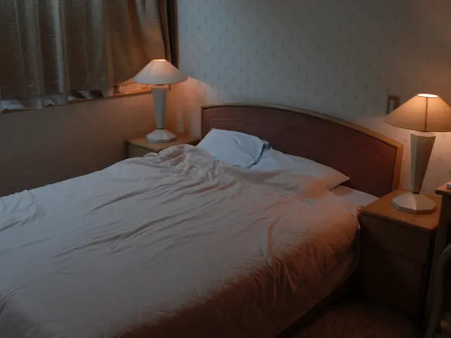 The image shows a bedroom with a bed, two nightstands with lamps on them, a chair, a curtain, and a...