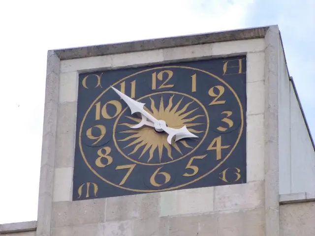 The image shows a clock on the side of a building with windows, set against a backdrop of a clear...