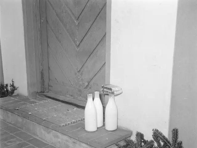 The image shows a black and white photo of three bottles of milk sitting on the steps of a house,...
