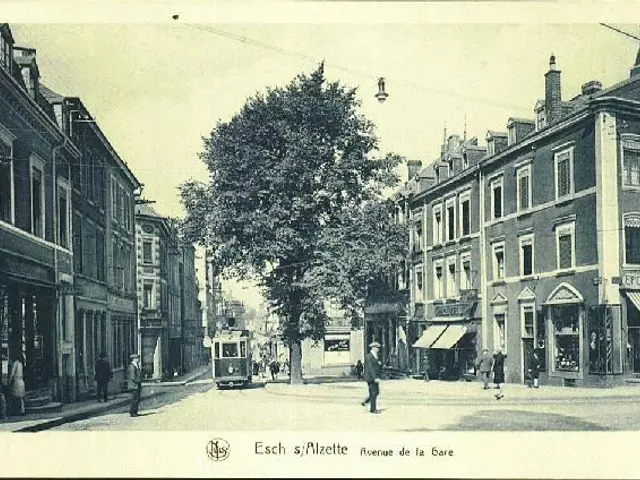 The image shows an old black and white photo of a city street with a tram on the road, people...
