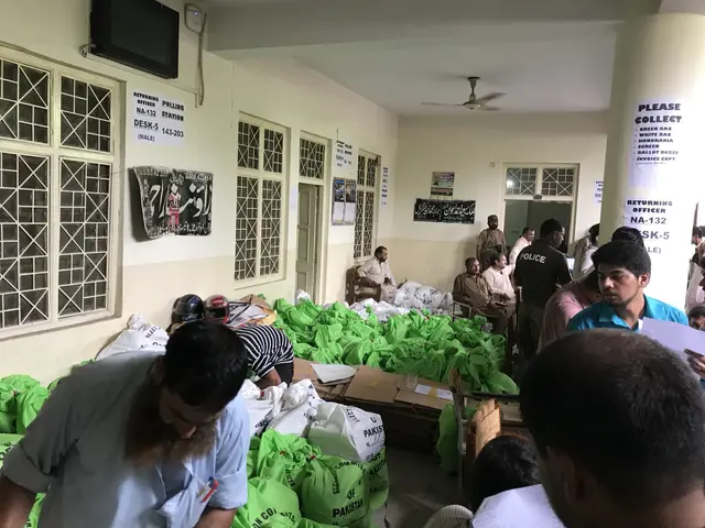 The image shows a group of people standing around a room filled with bags of food. There are people...