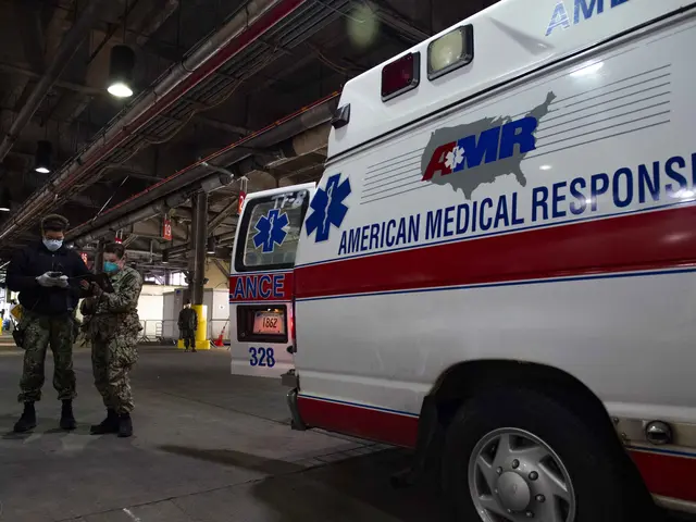 The image shows an American Medical Response (AMR) ambulance parked inside of a building, with two...