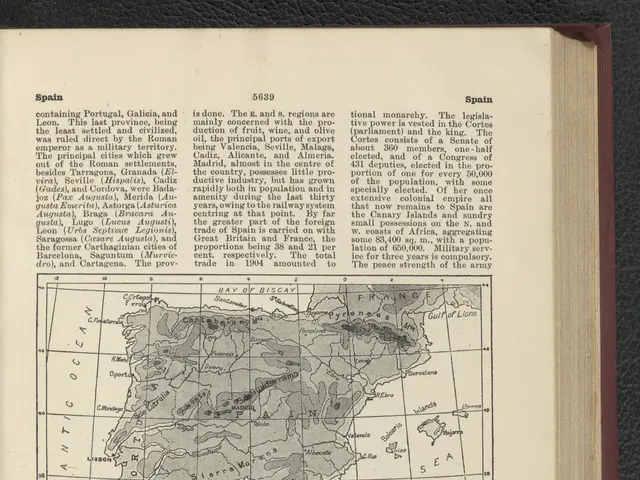 The image shows an open book with a map of Spain on it, placed on a black surface. The book...