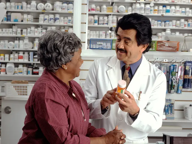 The image shows a pharmacist talking to a customer in a pharmacy. The pharmacist is wearing a white...