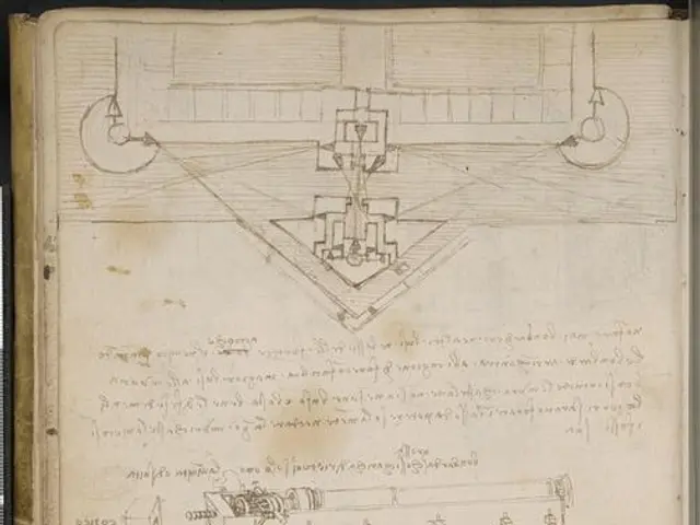 The image shows an open book with a drawing of a machine on it, which is believed to be Leonardo da...