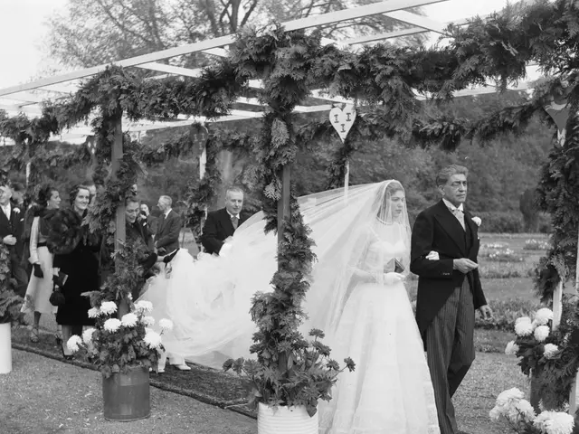 The image shows a bride and groom walking down the aisle at their wedding, surrounded by a group of...