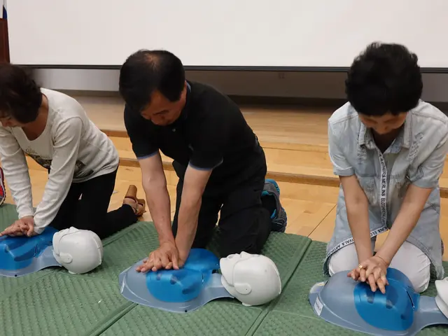 The image shows a group of people sitting on top of a green mat, with helmets placed on the floor...