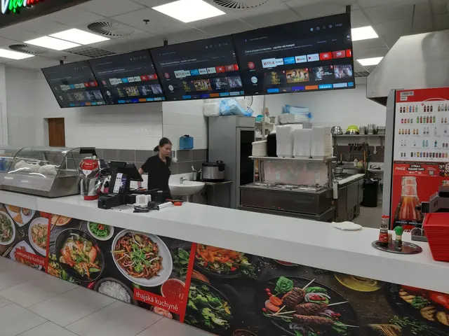 The image shows a woman standing in front of a counter in a restaurant. On the counter there are...