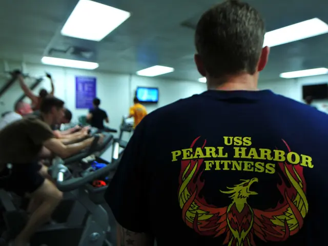 The image shows a group of people riding stationary bikes in a gym, with a man in the foreground...