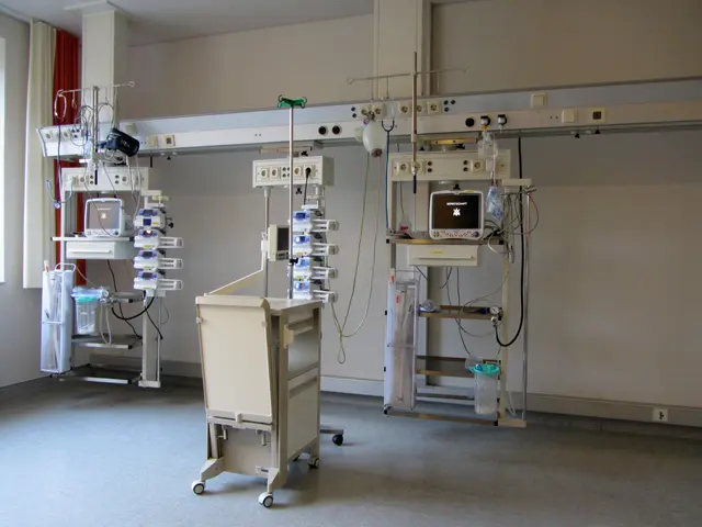 The image shows a hospital room with a variety of medical equipment, including monitors, stands,...