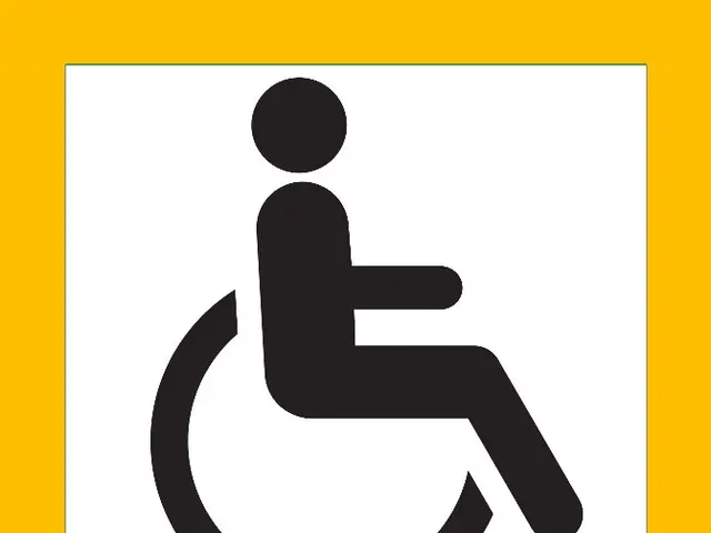 The image shows a yellow and white sign with a black and white image of a person in a wheelchair,...
