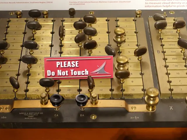 The image shows a close up of an electronic device on display in a museum, with a board in the...