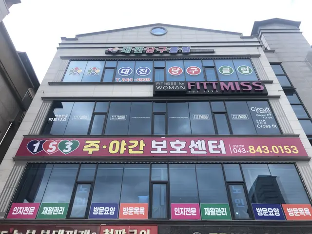 The image shows a building with a sign that reads "Fitness for Woman" in Seoul, South Korea. The...