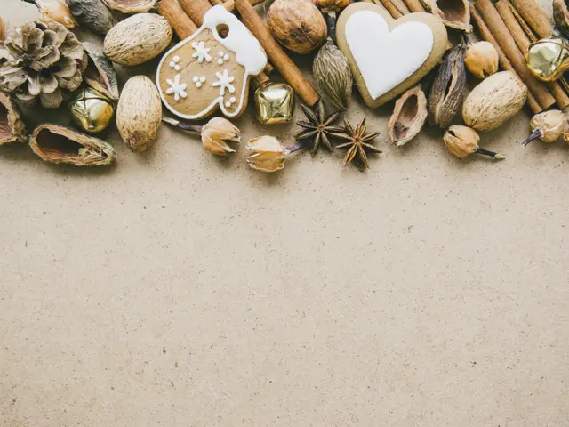The image shows a variety of nuts and spices arranged in the shape of a heart on a brown...