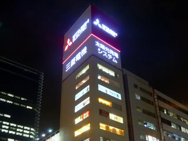 The image shows a city street at night with a bus driving down it, surrounded by tall buildings...