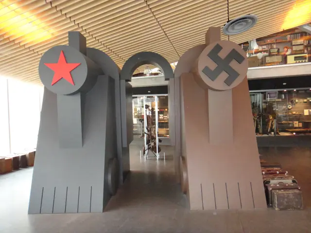 The image shows a large metal sculpture with a red star on it in the middle of a room. On the right...