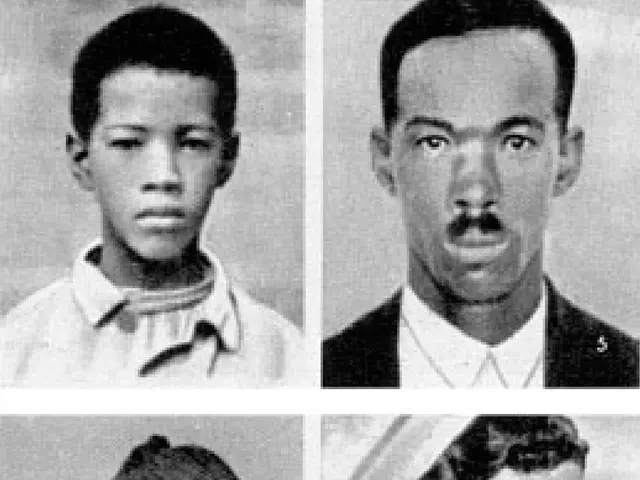 The image shows a black and white photo of four people, two men and two women, all of whom are...