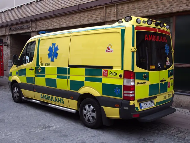The image shows an ambulance parked in front of a brick building, with a fire extinguisher on the...
