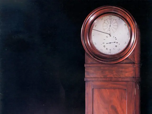 The image shows an old clock sitting atop a wooden table, with a dark background. The clock has a...